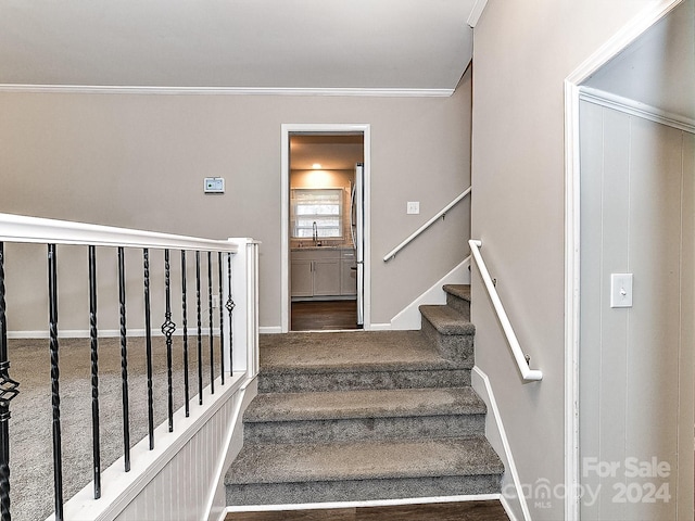 stairway with crown molding and sink