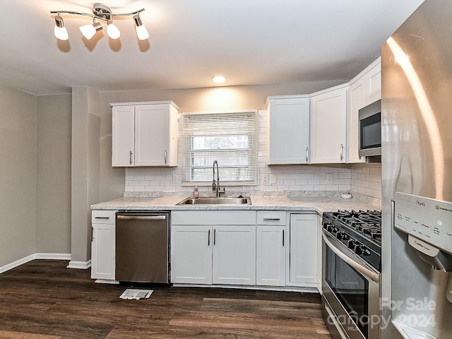 kitchen featuring decorative backsplash, stainless steel appliances, dark wood-type flooring, sink, and white cabinetry