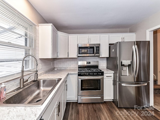 kitchen with backsplash, sink, white cabinetry, and stainless steel appliances