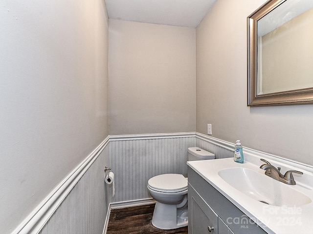 bathroom featuring wood-type flooring, vanity, and toilet