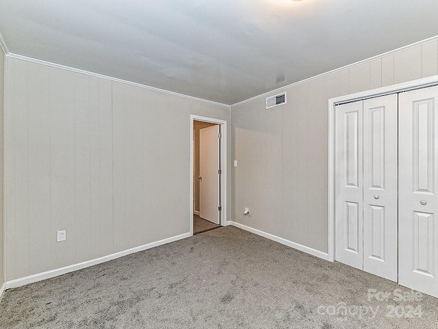 unfurnished bedroom featuring light carpet, a closet, and ornamental molding