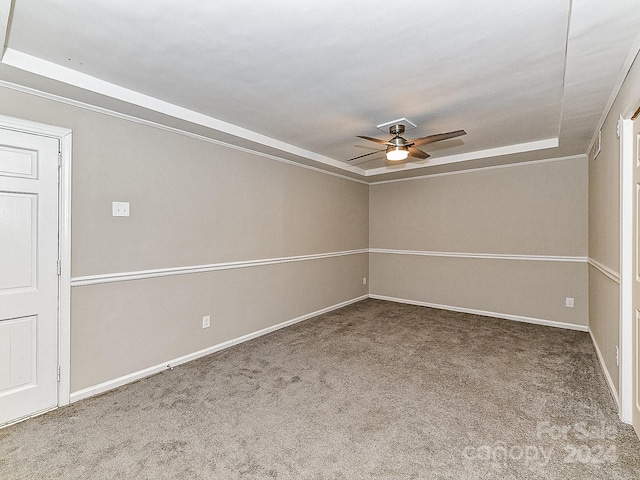 spare room featuring carpet flooring, ceiling fan, and a tray ceiling