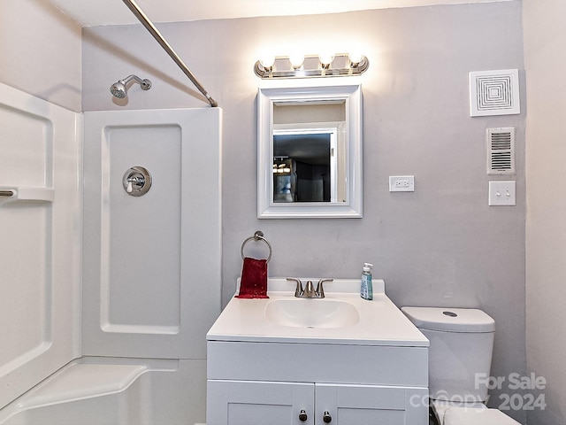 bathroom featuring a shower, vanity, and toilet