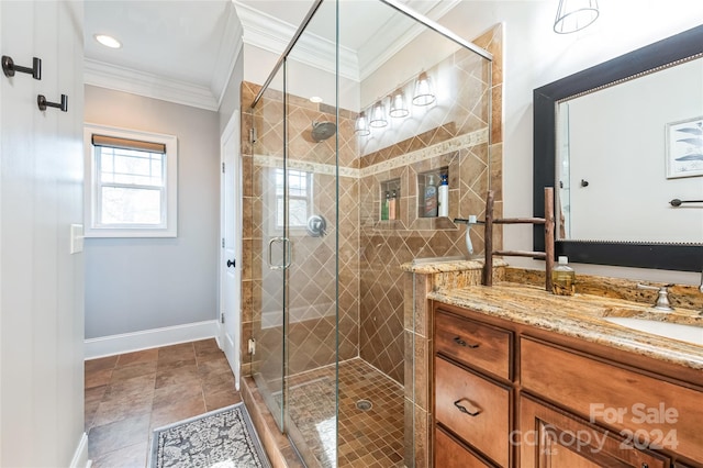 bathroom featuring vanity, a shower with shower door, and ornamental molding