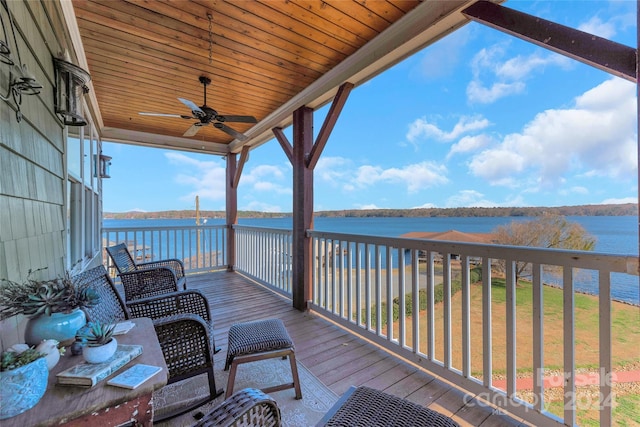 wooden terrace with ceiling fan and a water view