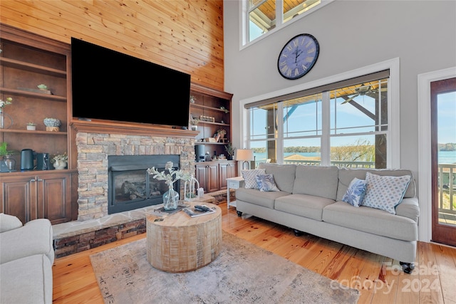 living room featuring a wealth of natural light, high vaulted ceiling, and light hardwood / wood-style flooring