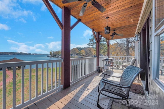 wooden deck with covered porch, a water view, and ceiling fan