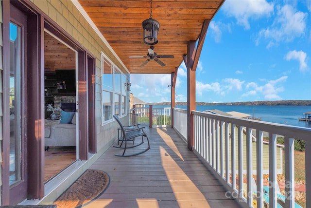 deck with a water view and ceiling fan