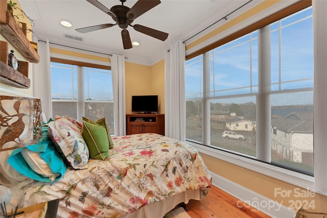 bedroom featuring ceiling fan, wood-type flooring, and ornamental molding