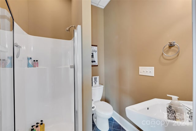 bathroom featuring tile patterned flooring, toilet, a shower, and sink