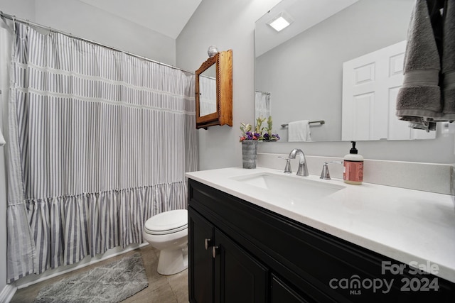 bathroom with tile patterned flooring, vanity, toilet, and curtained shower