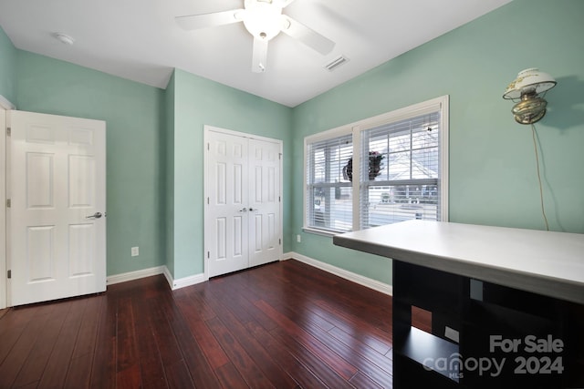 unfurnished bedroom featuring ceiling fan, dark wood-type flooring, and a closet