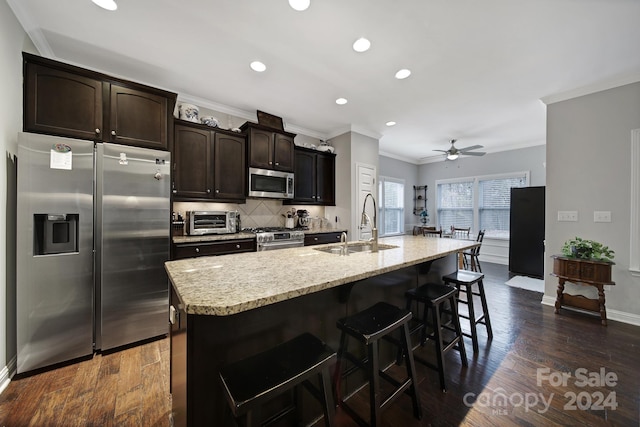 kitchen featuring sink, ceiling fan, an island with sink, dark hardwood / wood-style flooring, and stainless steel appliances