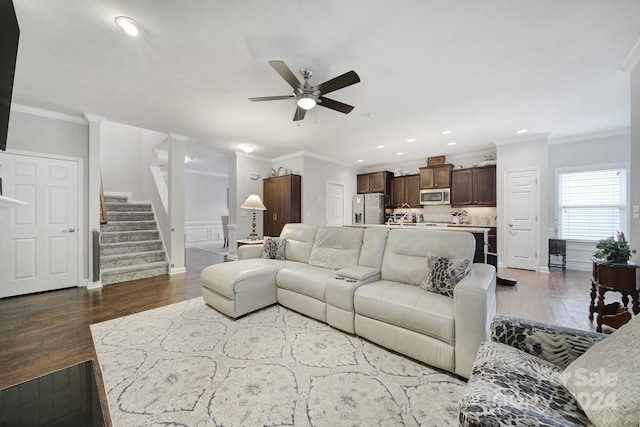 living room featuring dark hardwood / wood-style floors, ceiling fan, and ornamental molding