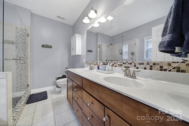 bathroom featuring decorative backsplash, vanity, tile patterned flooring, toilet, and a shower with shower door