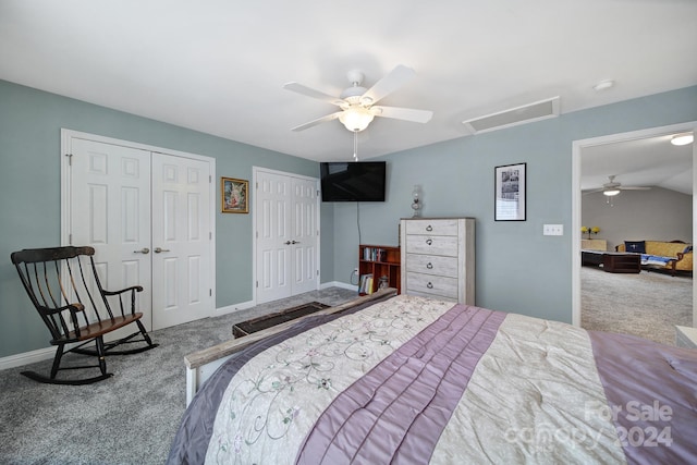 carpeted bedroom with lofted ceiling, ceiling fan, and multiple closets