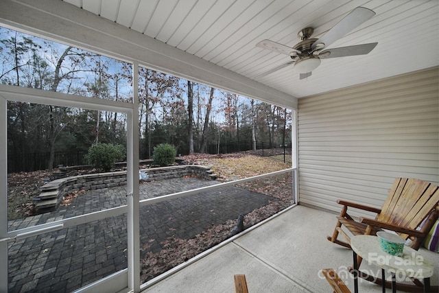 unfurnished sunroom featuring ceiling fan and a healthy amount of sunlight