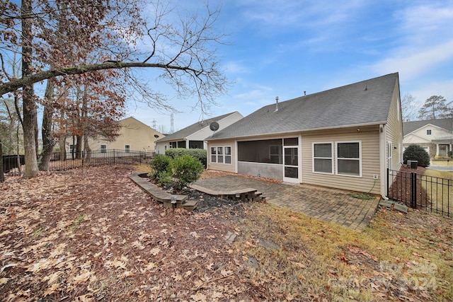 rear view of property featuring a sunroom