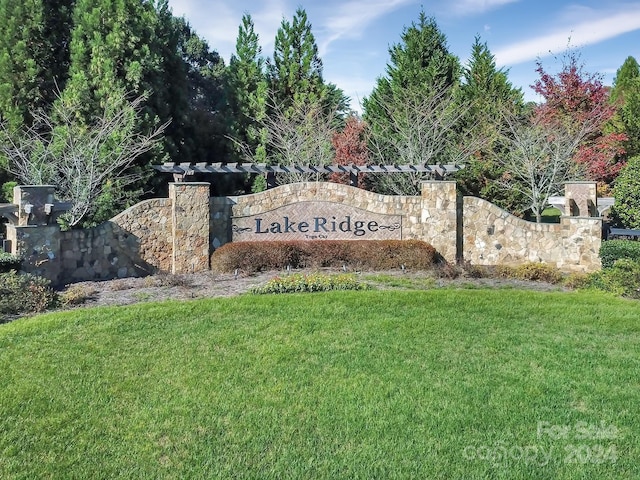 community / neighborhood sign featuring a lawn