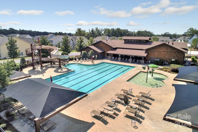 view of pool with a water slide and a patio