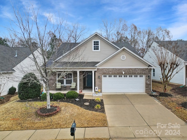 front facade featuring covered porch and a garage