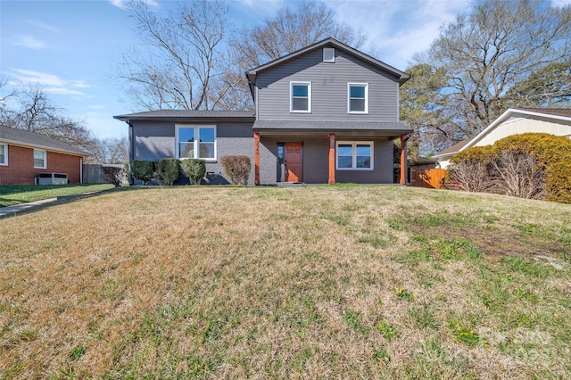 traditional home featuring a front yard, fence, and brick siding