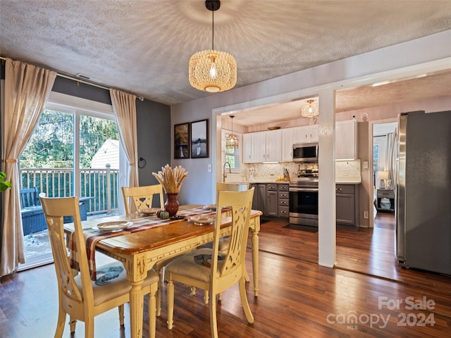 dining area featuring dark hardwood / wood-style flooring, a textured ceiling, and sink