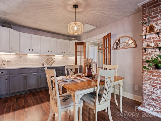 dining space with french doors, a textured ceiling, and dark wood-type flooring