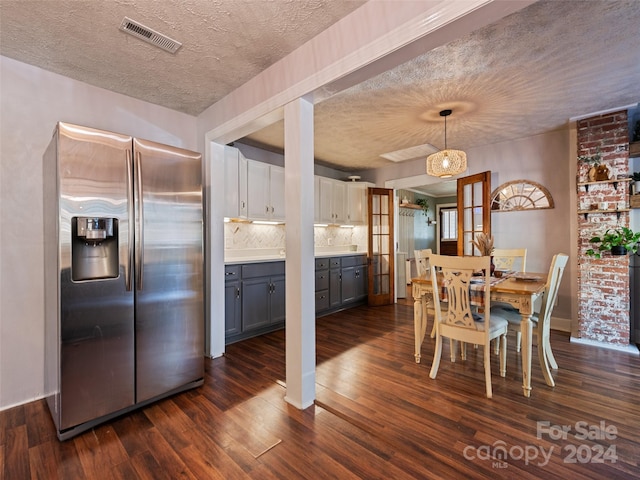 dining area with a textured ceiling and dark hardwood / wood-style floors