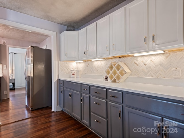 kitchen with decorative backsplash, stainless steel fridge, white cabinets, and dark wood-type flooring