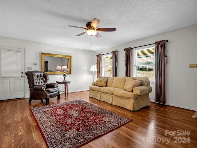 living room with hardwood / wood-style flooring, ceiling fan, and a textured ceiling