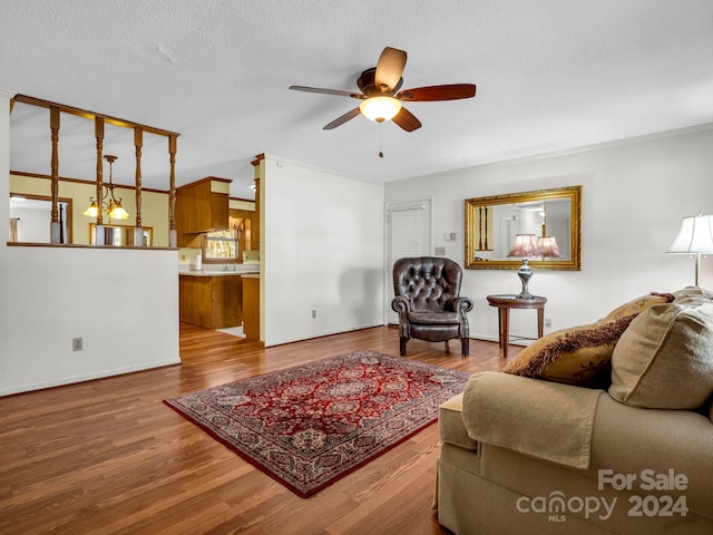 living room with hardwood / wood-style floors, ceiling fan, and a textured ceiling