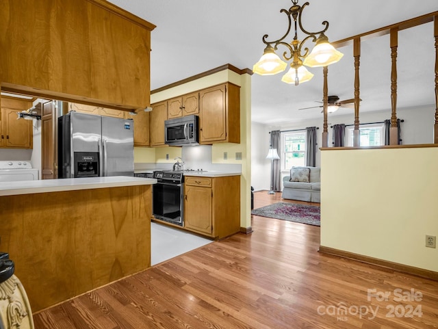 kitchen featuring appliances with stainless steel finishes, ceiling fan with notable chandelier, decorative light fixtures, light hardwood / wood-style flooring, and washer / clothes dryer