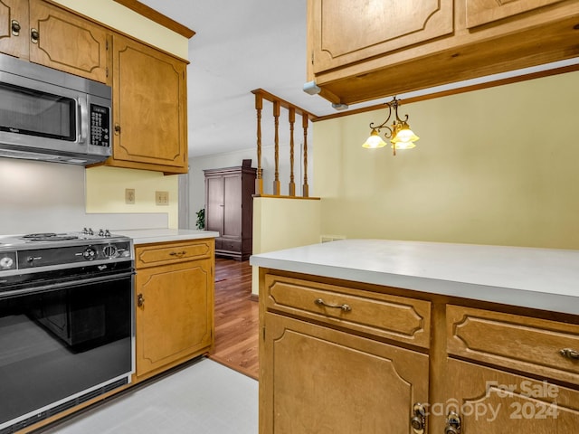 kitchen featuring decorative light fixtures, black range, a notable chandelier, and hardwood / wood-style flooring