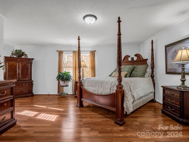 bedroom featuring a textured ceiling, dark hardwood / wood-style floors, and crown molding