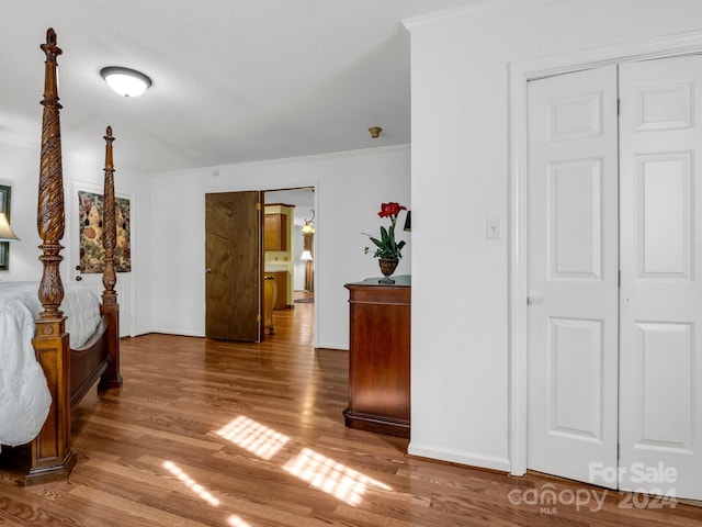 hall featuring hardwood / wood-style floors, a textured ceiling, and ornamental molding