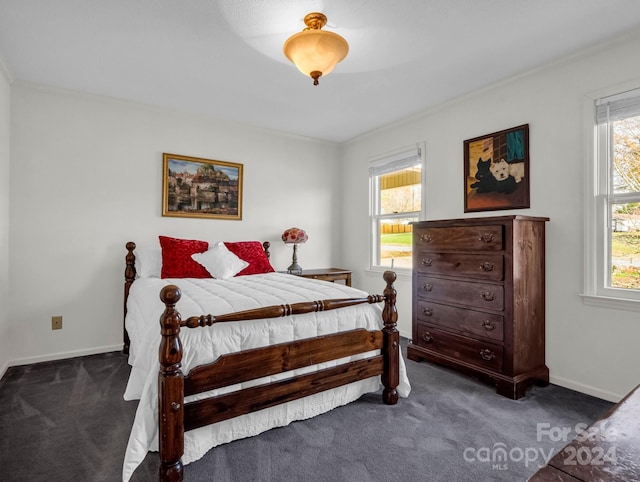 bedroom featuring dark carpet, multiple windows, and ornamental molding