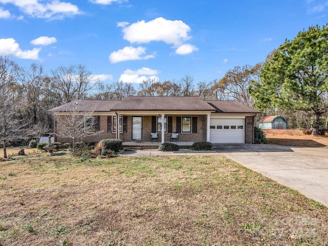 ranch-style home featuring covered porch, a garage, and a front yard