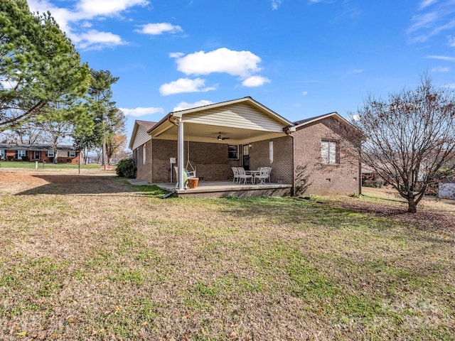 back of house featuring ceiling fan, a yard, and a patio