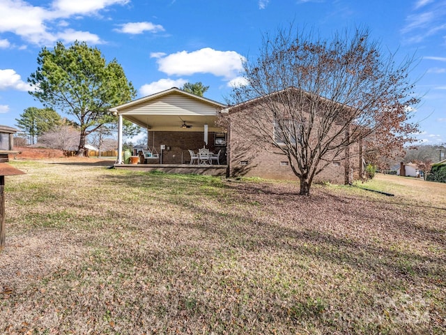 rear view of property with ceiling fan, a yard, and a patio