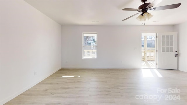 spare room with light hardwood / wood-style flooring, a wealth of natural light, and ceiling fan