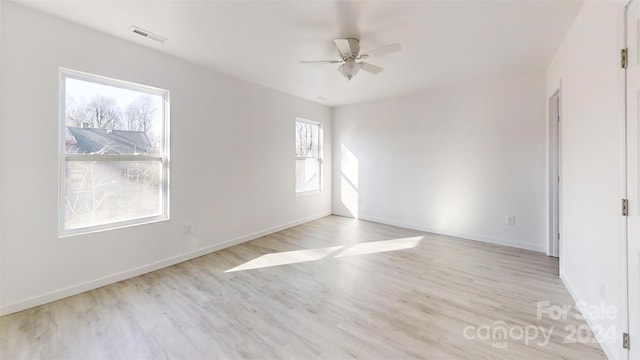 unfurnished room featuring a wealth of natural light, ceiling fan, and light wood-type flooring