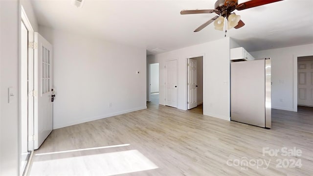 unfurnished bedroom featuring stainless steel refrigerator, ceiling fan, and light hardwood / wood-style floors