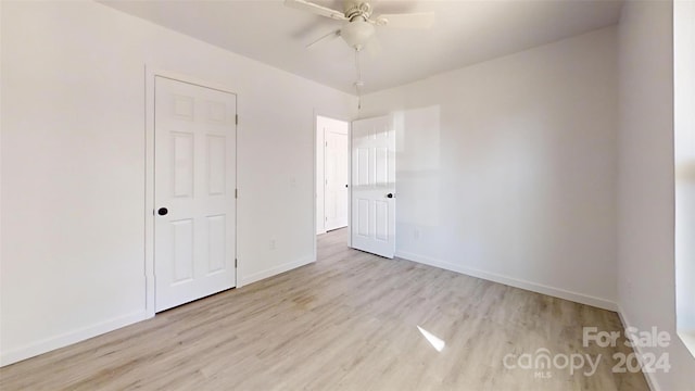 unfurnished bedroom featuring a closet, light hardwood / wood-style flooring, and ceiling fan