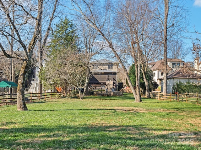 view of home's community with a lawn and fence