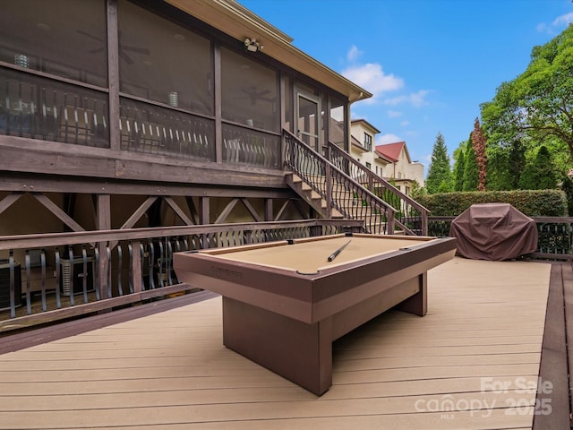 wooden terrace with a sunroom, grilling area, and stairway