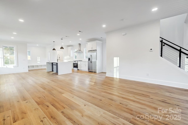 unfurnished living room with light hardwood / wood-style flooring and sink