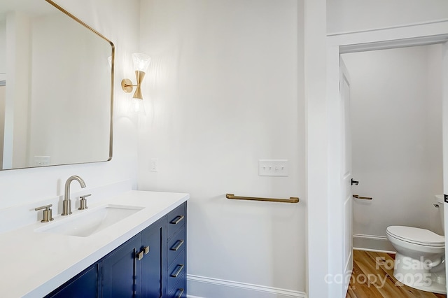 bathroom featuring hardwood / wood-style floors, vanity, and toilet