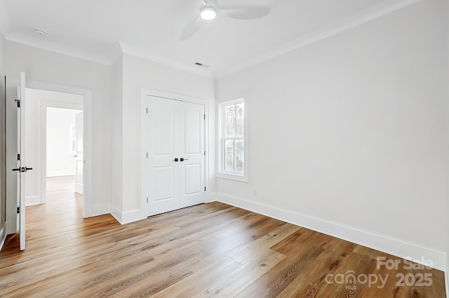 unfurnished bedroom with a closet, ceiling fan, crown molding, and light hardwood / wood-style floors