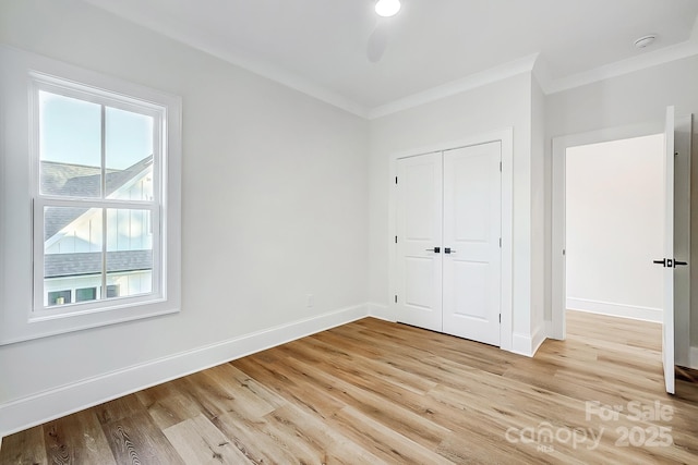 unfurnished bedroom with light hardwood / wood-style floors, a closet, and crown molding